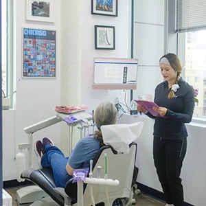 Dentist speaking to patient sitting in dental chair