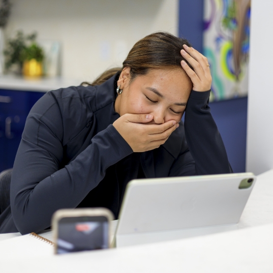 Woman at her work desk laying her face in her hands