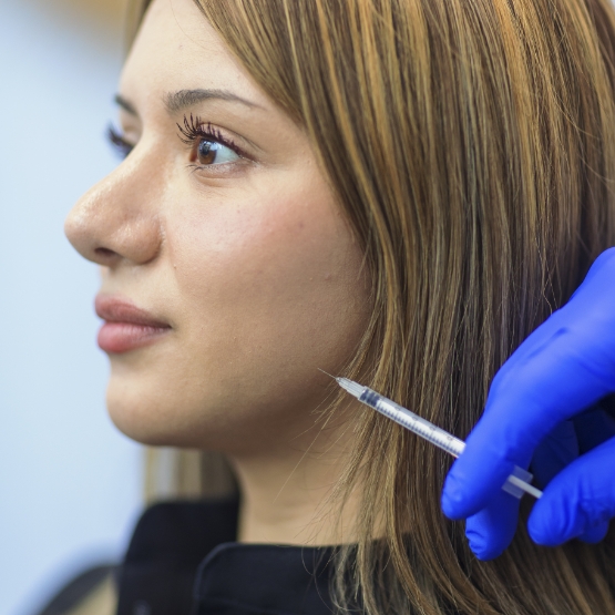 Woman receiving a BOTOX® injection near her jaw joint