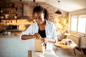 Woman opening box in kitchen area
